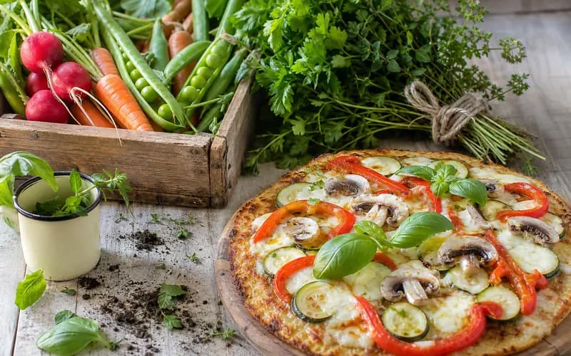 Pizza légère pâte chou-fleur garnie de courgette, poivron, champignons et mozzarella, servie sur une planche en bois